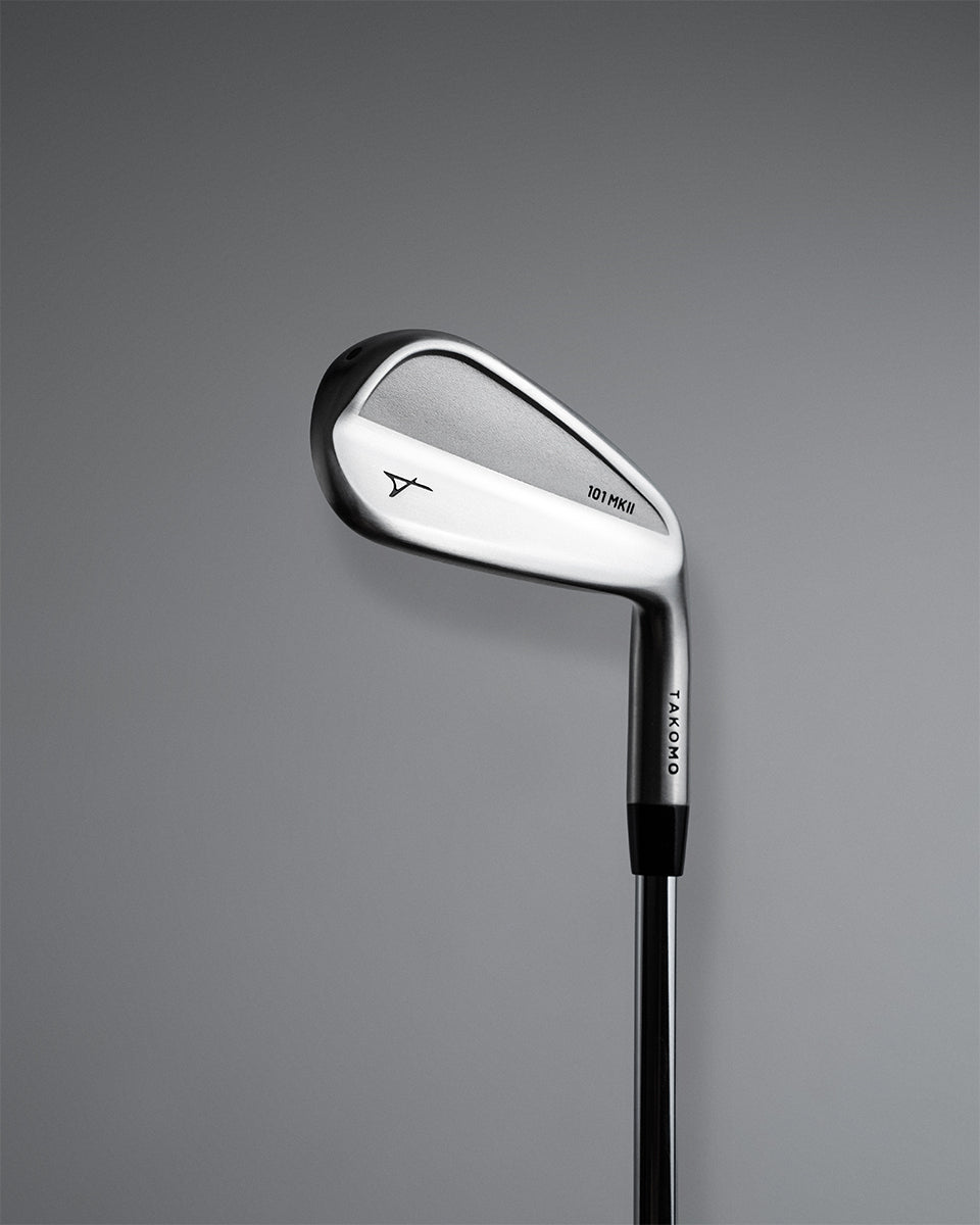 A Takomo Iron 101 MKII golf club shown from a side profile view against a dark gray gradient background.