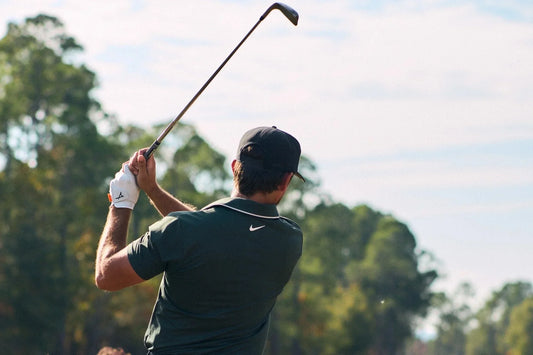 photo man in green shirt swinging golf club for iron distances