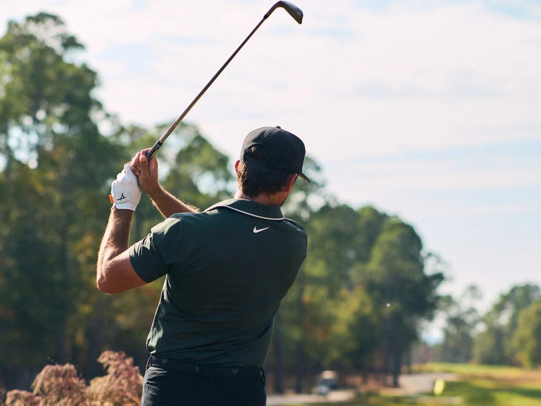 photo of man in green polo swinging hollow body irons