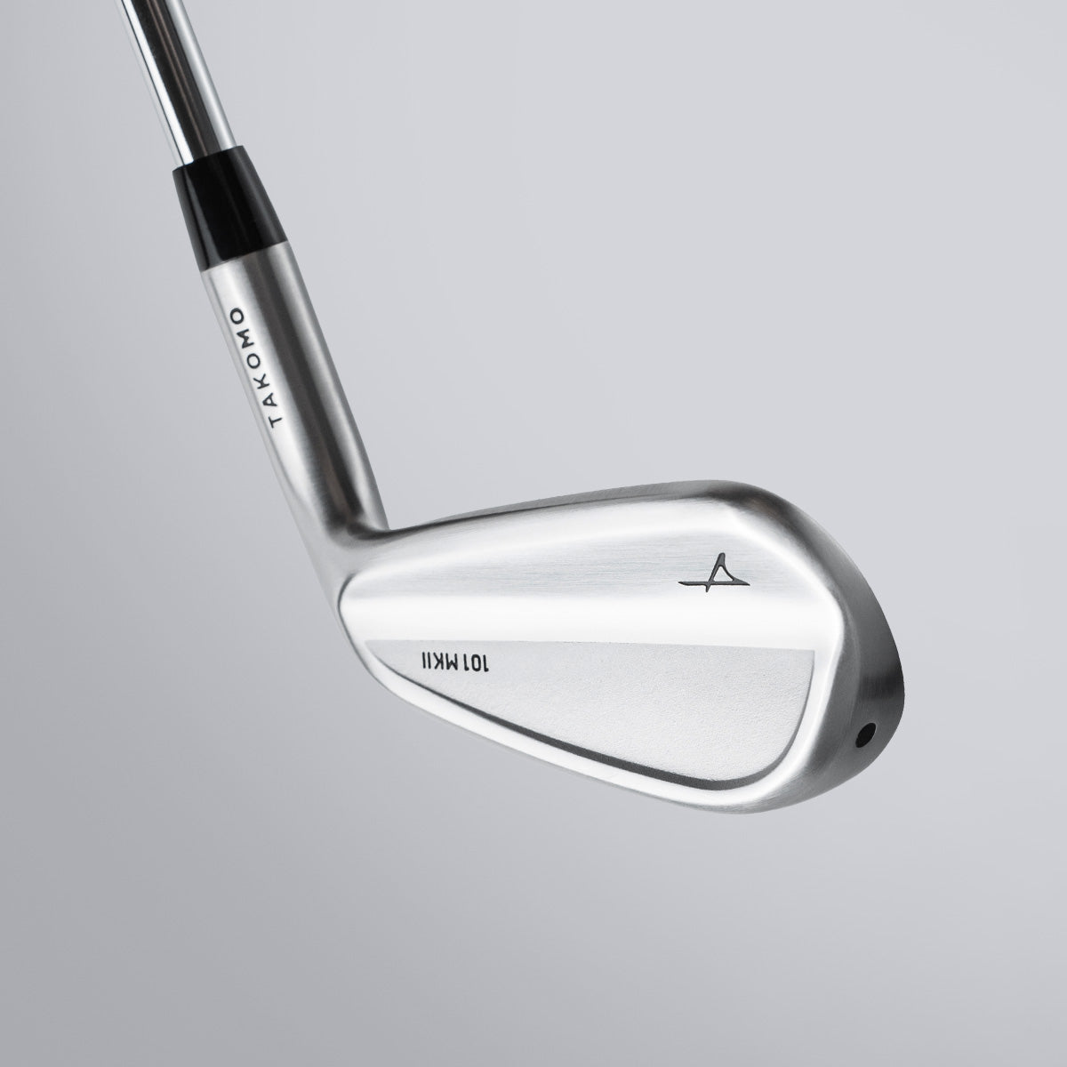 Golf club with a silver head and black shaft on a gray background