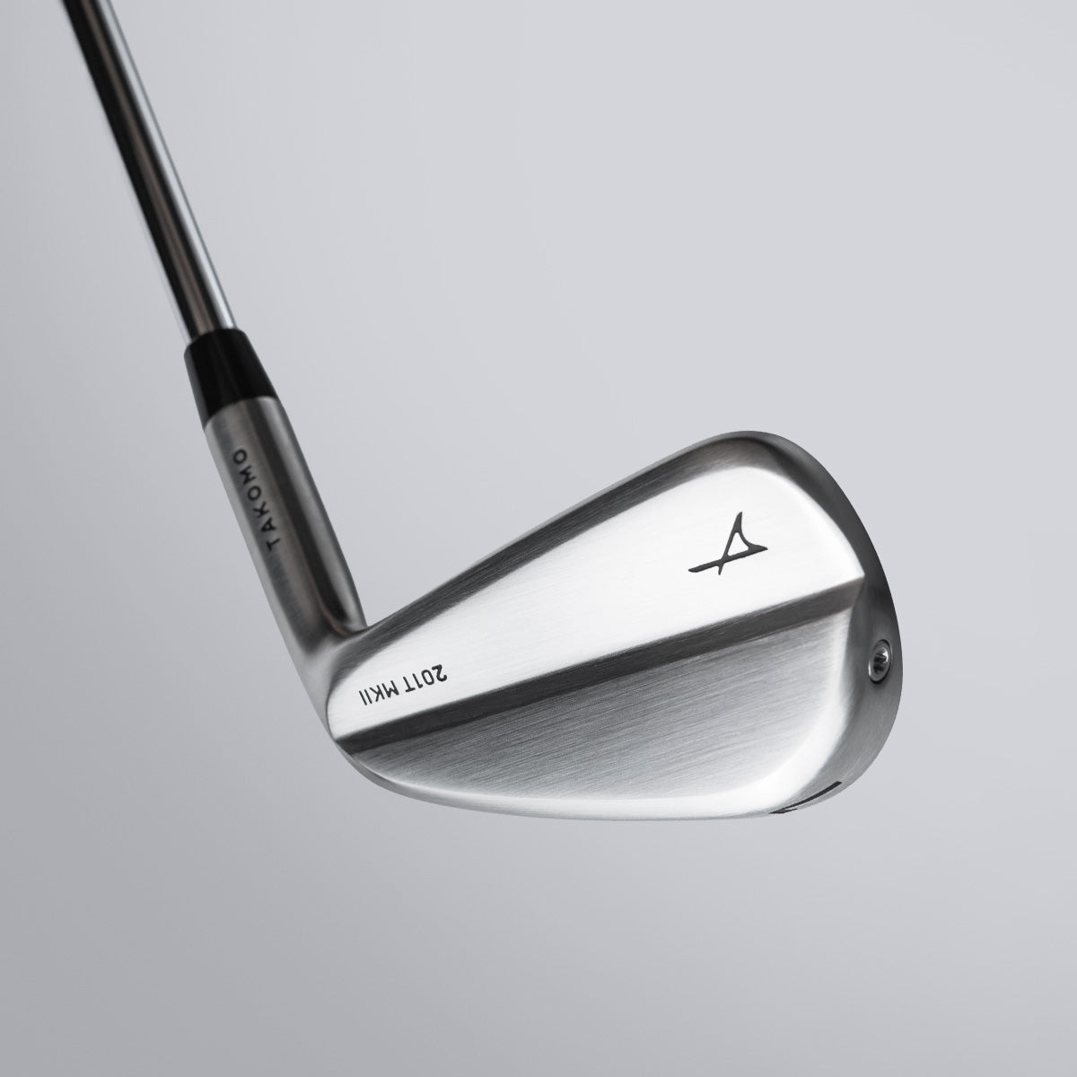 Golf club head with Takomo logo on a gray background