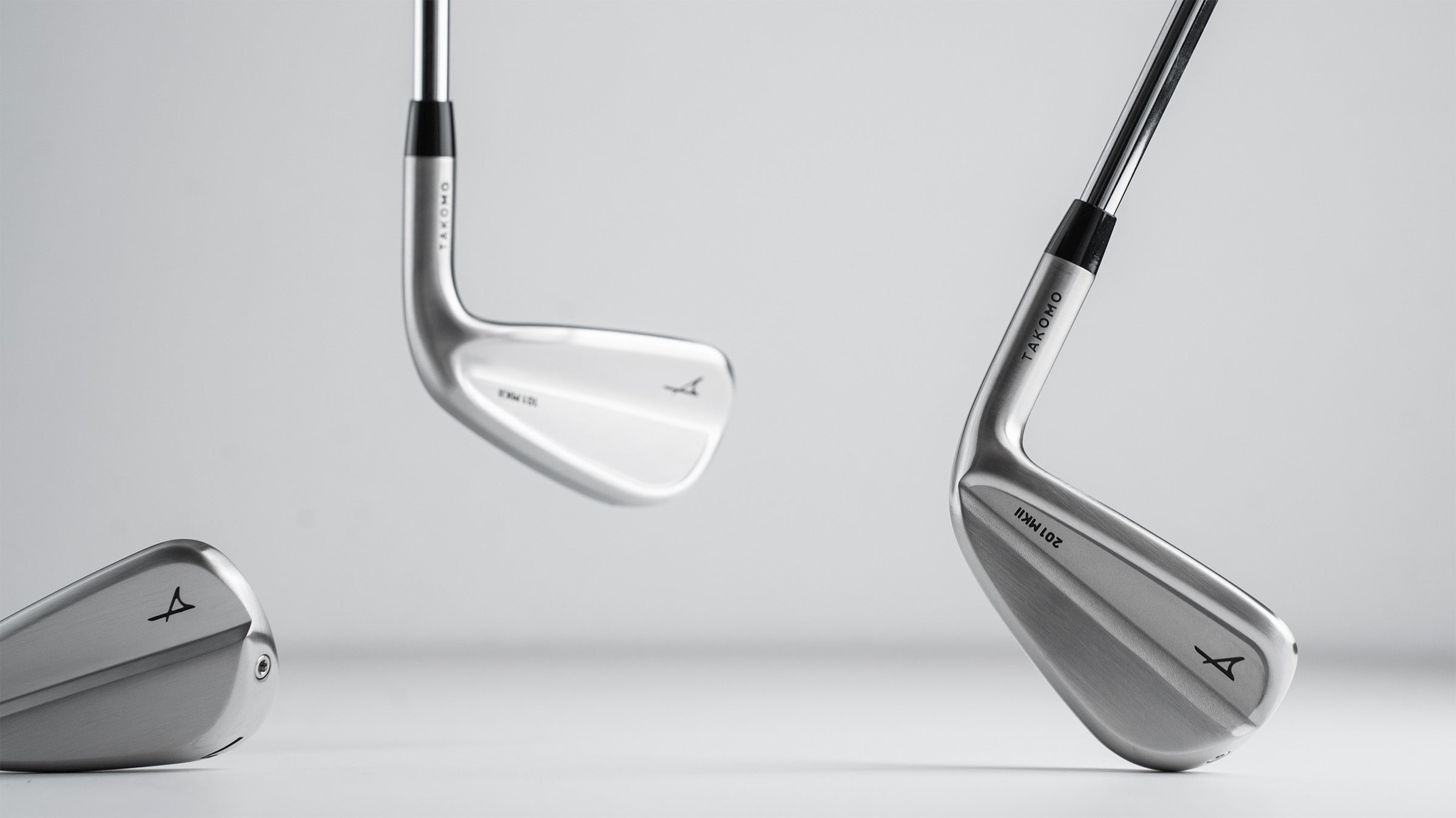 Takomo MKII golf irons on a light gray background
