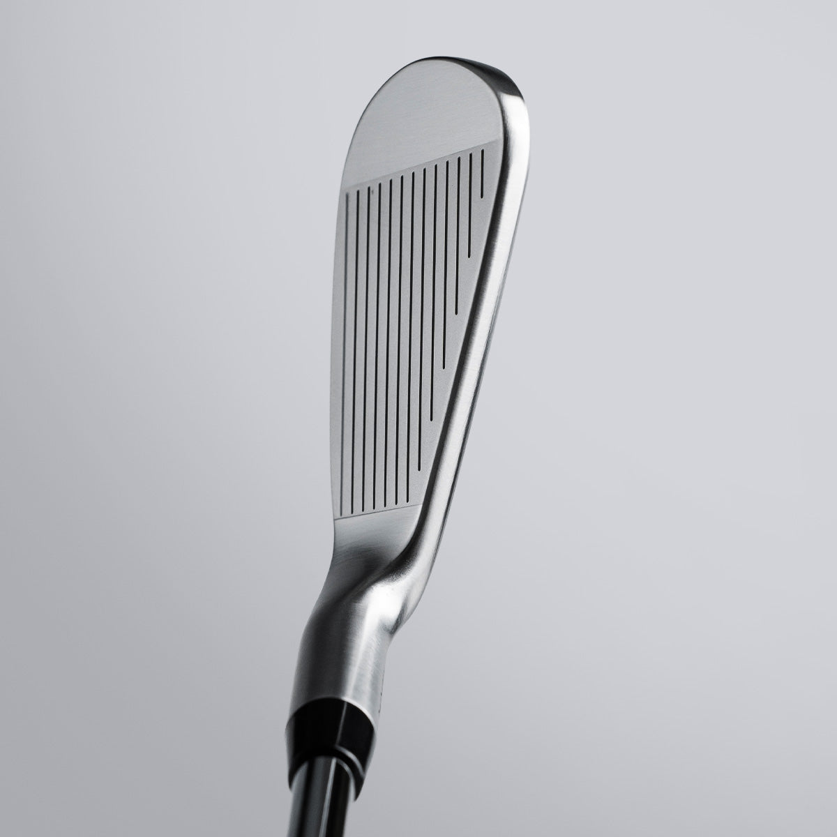 Close-up of a golf club head on a light gray background