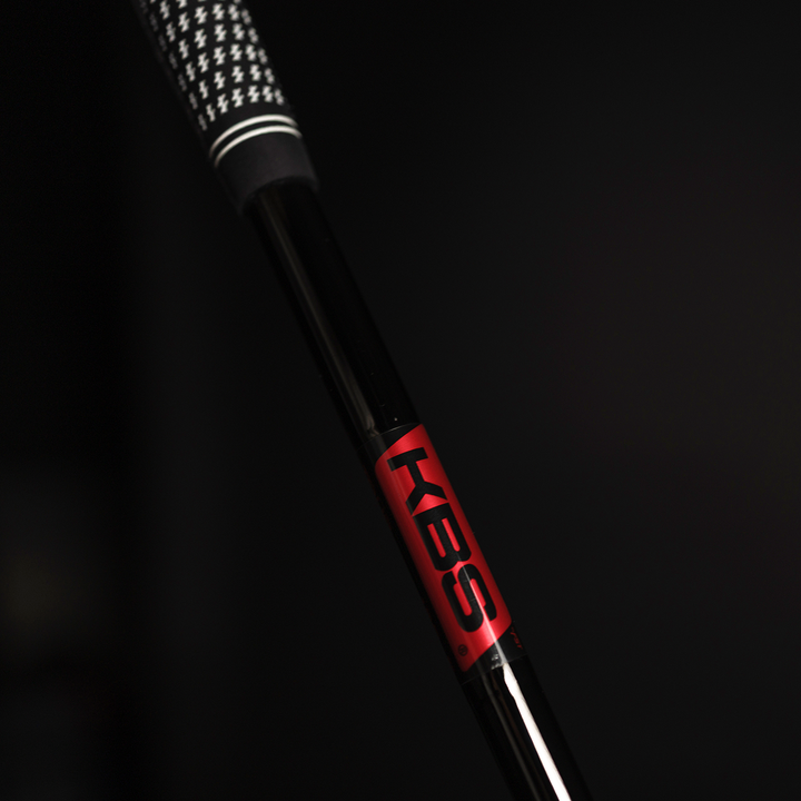 Close-up of a golf club shaft with 'KBS' branding on a black background