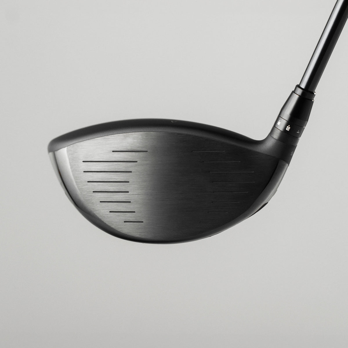 A close-up studio shot of a Takomo IGNIS D2 club head with part of the shaft visible, set against a solid light gray background.