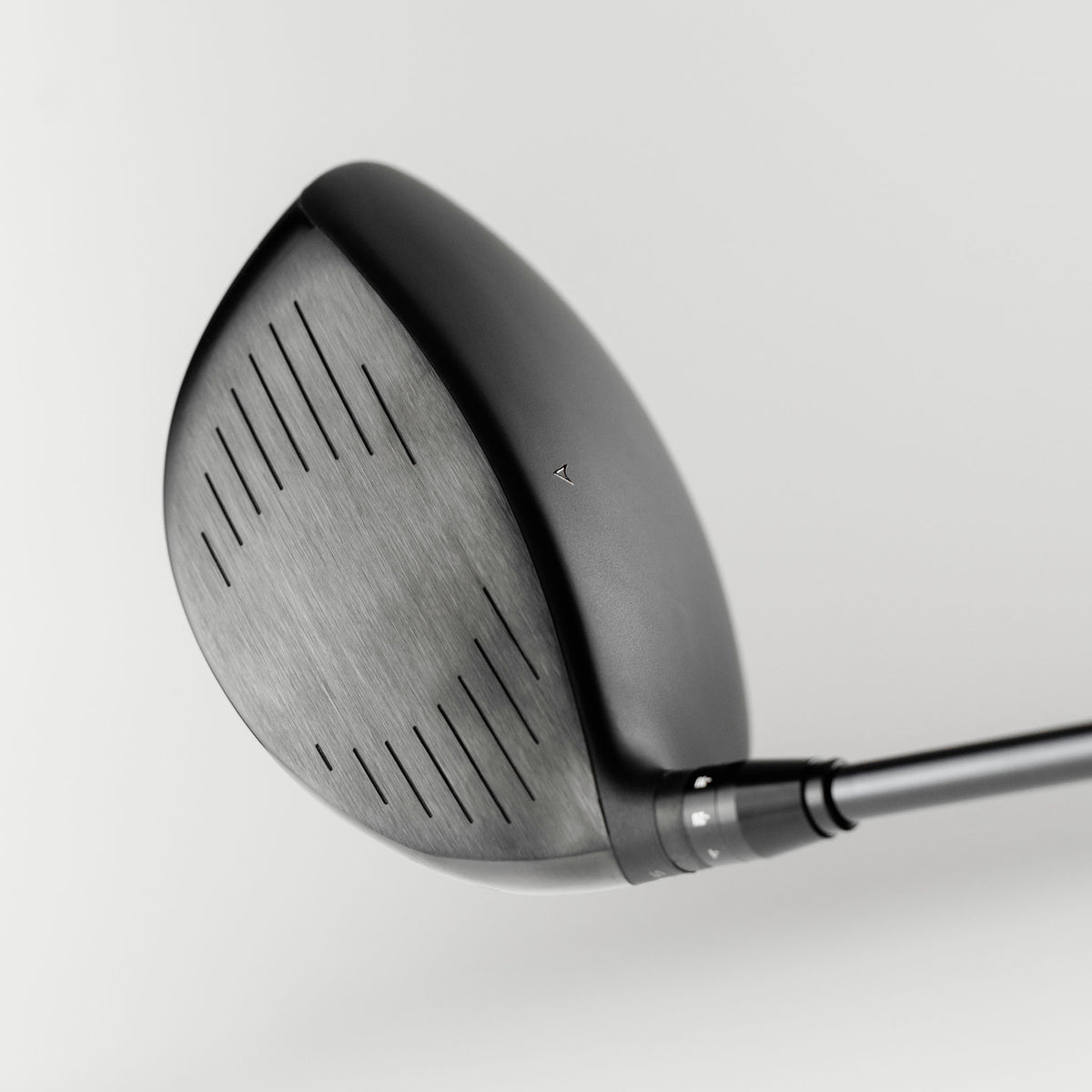 Close-up of a Takomo IGNIS D2 club head on a light gray background, showing the face plate of the driver.
