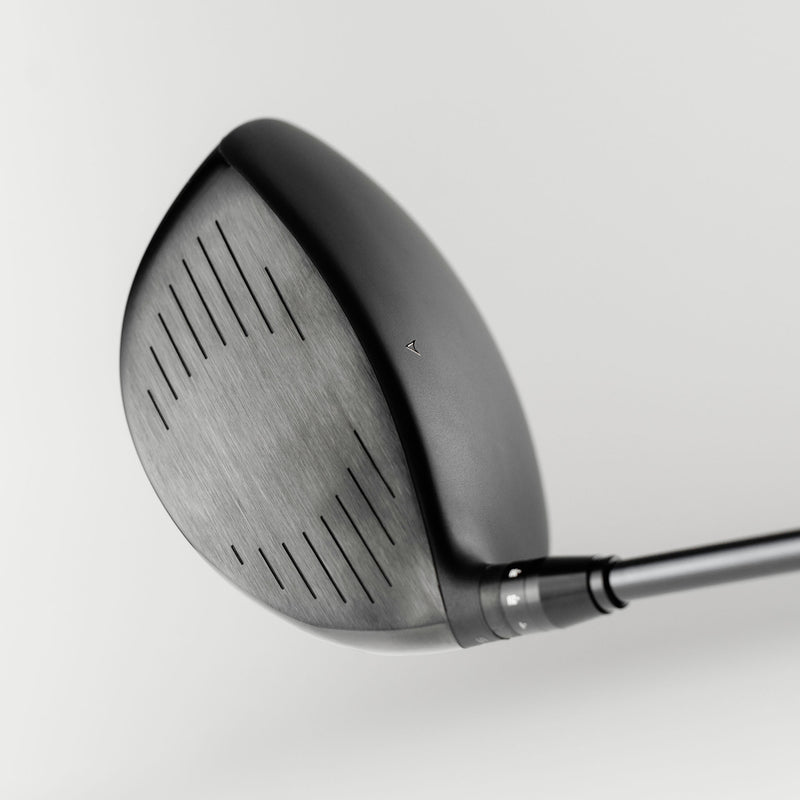 Close-up of a Takomo IGNIS D2 club head on a light gray background, showing the face plate of the driver.