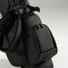 Black golf bag with brown accents on zippers on a gray background