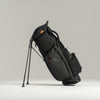 Black golf bag with stand on a light gray background
