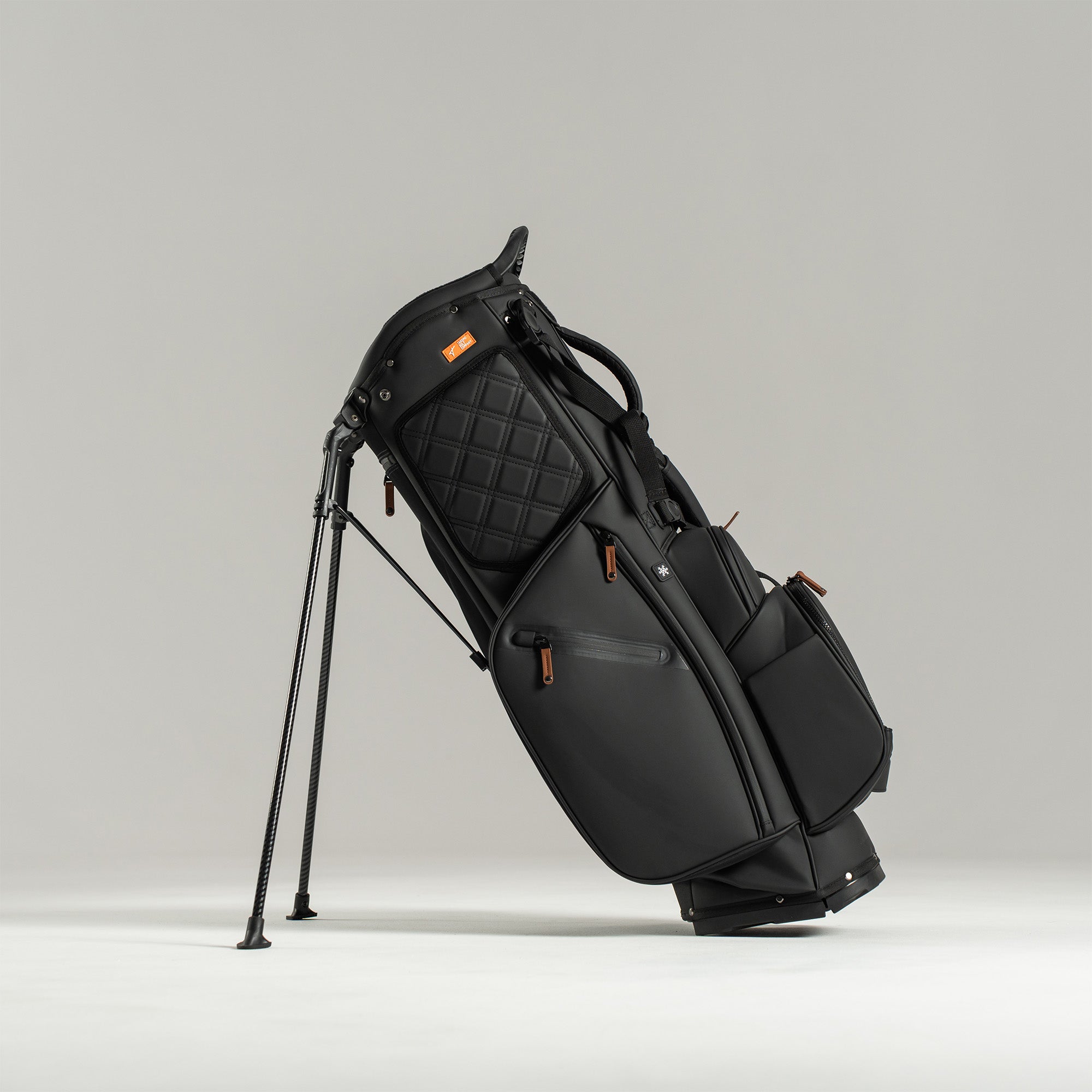 Black golf bag with stand on a light gray background