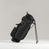 Black golf bag with stand on a light gray background
