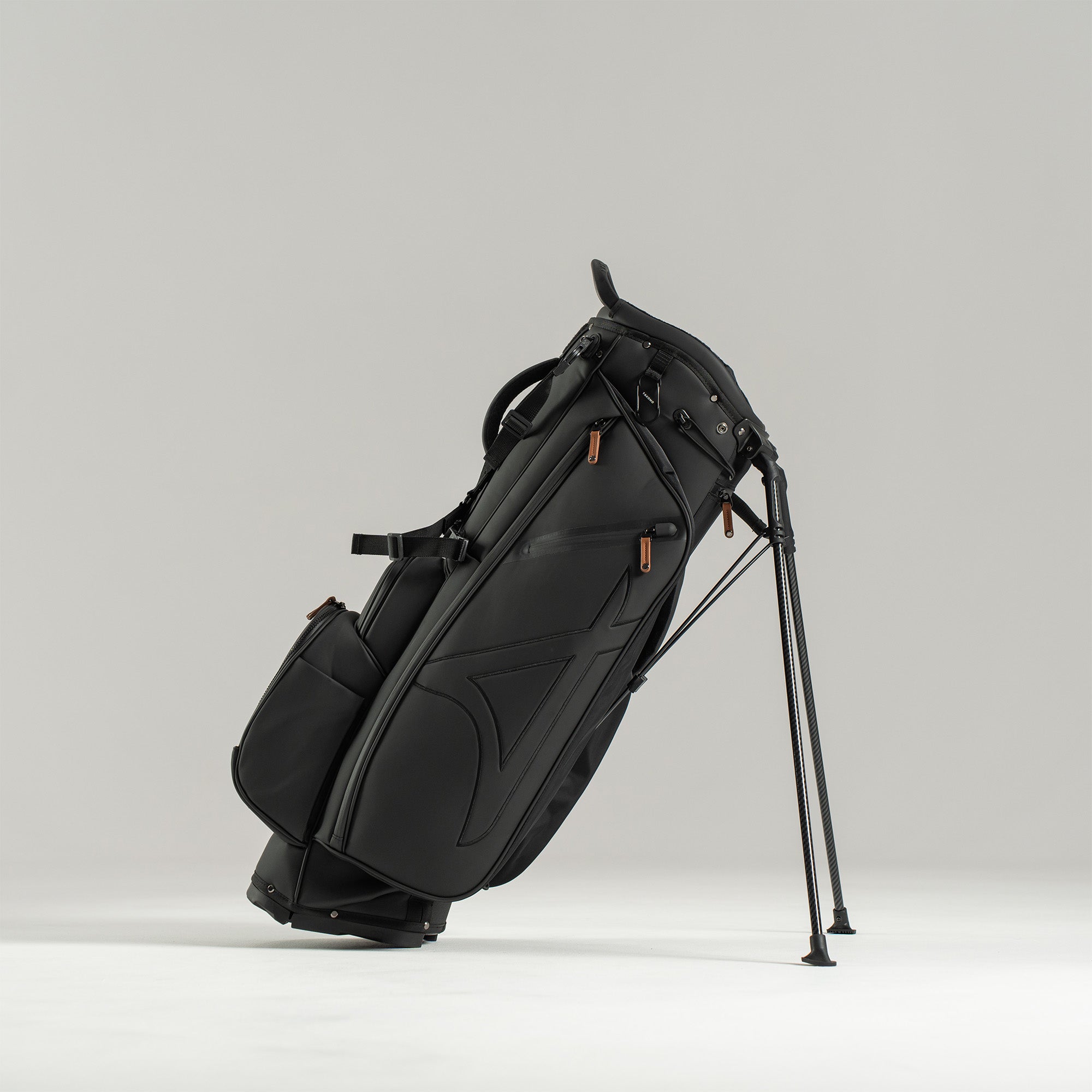 Black golf bag with stand on a light gray background