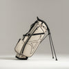 White golf bag with black straps on a light gray background