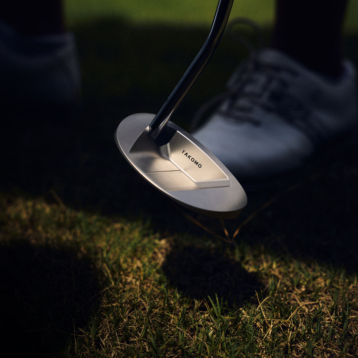 Takomo LUMO M1 mallet putter in high-contrast lighting outdoors.