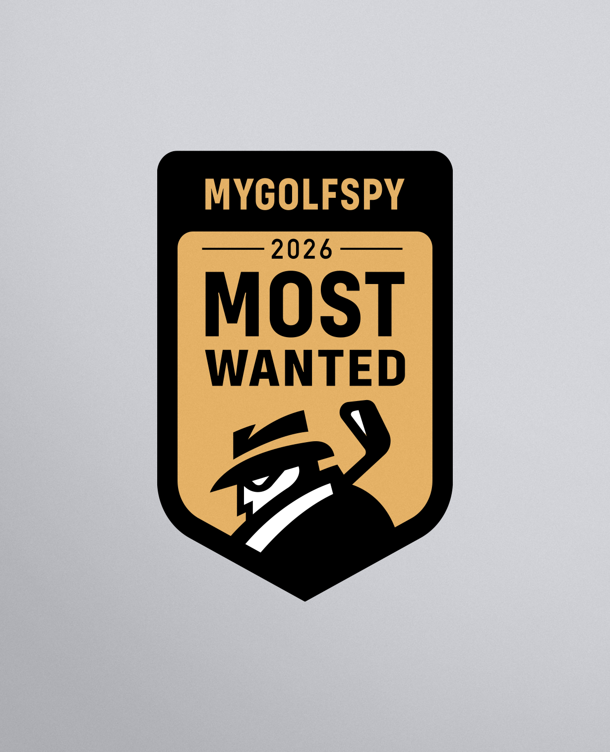 A shield-shaped graphic badge with a tan and black design reading 'MYGOLFSPY 2026 MOST WANTED' and a stylized black-and-white golf-tee character, centered on a light gray gradient background.